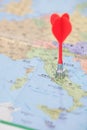 A red dart falls on the map of Italy