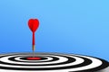 Red dart hit to center of dartboard with blue gradient background. Arrow on bullseye in target. Business success, investment goal Royalty Free Stock Photo