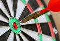 Red Darts arrow hitting in the target center of dartboard. Royalty Free Stock Photo