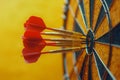 Red darts hitting the center of target on yellow background Royalty Free Stock Photo