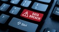 Red data breach warning sign highlighted on a computer keyboard with security alert symbols visible Royalty Free Stock Photo