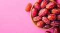 Red Dates in a Bowl on Pink Background Royalty Free Stock Photo