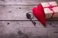 Red decorative heart, vintage key and gift box on aged wooden Royalty Free Stock Photo