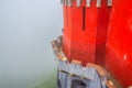 Red defense wall and tower with merlons of Pena Palace with green forest in fog background, Palacio Nacional da Pena