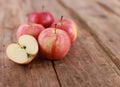 Red delicious apples and freshly sliced apple pieces on rustic wooden table - close up