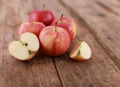 Red delicious apples and freshly sliced apple pieces on rustic wooden table - close up