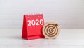 Red Desk Calendar with White 2026 Numbers and Target Icon on Wooden Surface Royalty Free Stock Photo