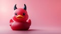 Red devil rubber duck with horns on a pink background. Royalty Free Stock Photo