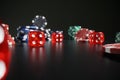 Red dice and colorful poker chips scattered on dark table