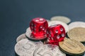 Red dice lie on different coins won at casino bets