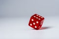 Red dice standing in equilibrium on the edge and showing 6 on a white table, red hexagonal cube standing in equilibrium