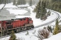 Red Diesel Locomotive on Tracks Running By a River During a Blizzard Royalty Free Stock Photo