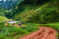 Red dirt country road to hilltribe village in the valley.