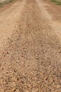 A red dirt gravel road with wheel tracks leading into the distance Royalty Free Stock Photo