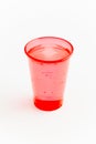 Red disposable plastic cup with water on white background Royalty Free Stock Photo