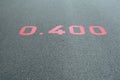 A red distance sign numbers 0.400 KM marken on surface the street in the parks