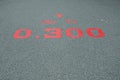 A red distance sign numbers 0.300 KM marken on surface the street in the parks