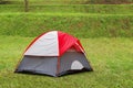 Red dome tent on green grass in camping site Royalty Free Stock Photo