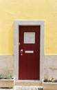 Red door against yellow wall Royalty Free Stock Photo