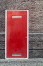 A red door embedded in a stone wall Royalty Free Stock Photo