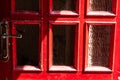 red door with glass inserts and golden door handle in the bright sun and in the shade Royalty Free Stock Photo