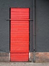 Red door in a gray wall_vertical Royalty Free Stock Photo