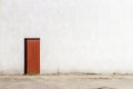 Red door in the middle of a gray concrete wall Royalty Free Stock Photo