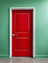 Red door set in a green wall creating a vibrant contrast. Royalty Free Stock Photo