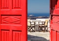 Red door and view of terrace in the Greek island of Santorini. Royalty Free Stock Photo