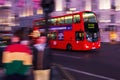 Red double decker bus in motion blur at Piccadilly Circus in London, UK, at night Royalty Free Stock Photo