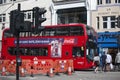 Red double-decker bus stops at a traffic light near Liverpool street