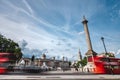 Red Double Decker busses passing the Trafalgar Square in front of the Nelson column Royalty Free Stock Photo
