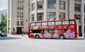 Red double-decker city tour bus rides on Novaya Square in town