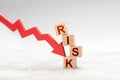 Red down arrow knocks down the cube RISK. Risky fall or investment concept Royalty Free Stock Photo