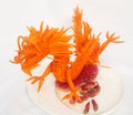 Red dragon carved from a carrot on a white background - Food carving close up image