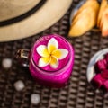 Red Dragon fruit and apple juice in a glass decorated with Plumeria flower. Hat, cut apples and dragon fruit, ice cubes. On a dark Royalty Free Stock Photo