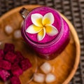 Red Dragon fruit juice in a glass, decorated with Plumeria flower, cut dragon fruit and ice cubes. Royalty Free Stock Photo