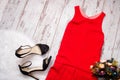 Red dress, black shoes and bouquet. Imitation fur on a wooden background, fashionable concept, top view Royalty Free Stock Photo