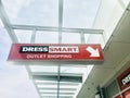 Red Dress Smart outlet shopping signs and arrow hanging outside of the building.