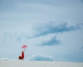 Red dress with umbrella and suitcase on the beach Royalty Free Stock Photo