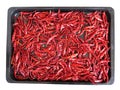 Red dried chilli on black tray isolated on white background