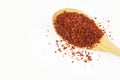 Red dried crushed hot chili pepper flakes or powder in wooden spoon isolated on white background Royalty Free Stock Photo