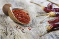 Red dried crushed hot chili peppers and chili flakes or powder in wooden spoon on wooden rustic background Royalty Free Stock Photo