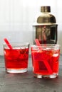 Red drink with ice. Cocktail making bar tools, strawberry and thyme leaves