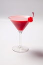 Red drink in martini glass, garnished with marachino cherry. on white background Royalty Free Stock Photo