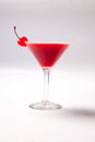 Red drink in martini glass, garnished with marachino cherry. on white background Royalty Free Stock Photo