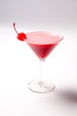 Red drink in martini glass, garnished with marachino cherry. on white background Royalty Free Stock Photo