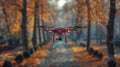 A red drone is flying over a forest with leaves on the ground Royalty Free Stock Photo
