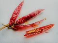 Red dry chillies with half opened and yellow seeds.