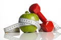 Red Dumbbells, fresh green apple and measuring tape Royalty Free Stock Photo